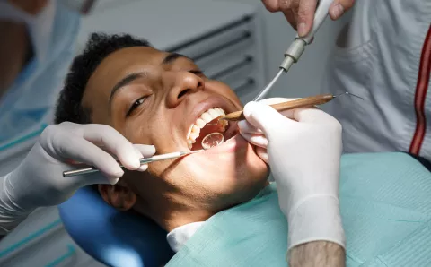 Patient undergoing an oral cancer screening at a routine dental appointment.
